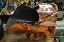 A copper coal scuttle.