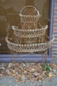 A wire work three-tier demi-lune plant stand.