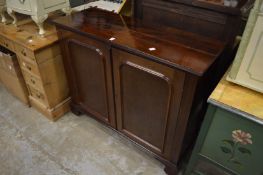 A mahogany two door cabinet containing a rise and fall flat screen TV.
