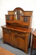 An Arts and Crafts mahogany sideboard with upper section having circular mirror and glazed cupboards
