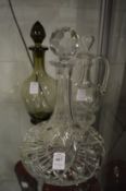 A cut glass port decanter, a claret jug and a smoky glass decanter.