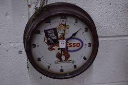 A novelty circular wall clock 'Esso put a tiger in your tank'.