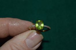 A gilded silver ring set with a 2.5ct oval cut peridot, with certificate.