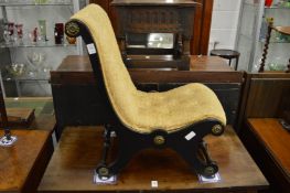 A Victorian ebonised small slipper chair.