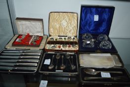 Various cased sets of silver flatware and a cased cruet set with silver rims.