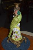 A pair of decorative porcelain and ormolu parrot candlesticks.
