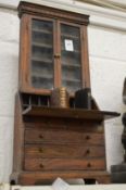 An oak miniature bureau bookcase containing two miniature books.