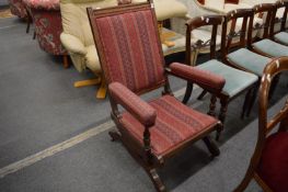 An American walnut framed and upholstered rocking chair.