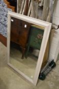 A wall mirror with painted frame.