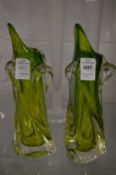 A pair of lime green glass vases of naturalistic form.