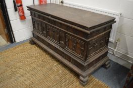 A Continental carved hardwood cassonne with double rising top, a door to the front enclosing small