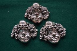 Three white metal clown faces.