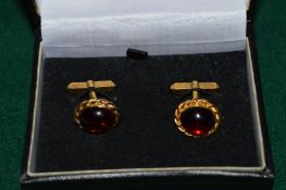 A pair of 9ct gold cufflinks set with oval cabochon stones.