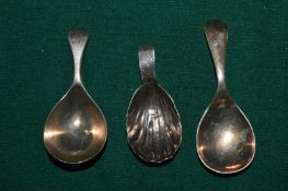 Two silver caddy spoons and a plated caddy spoon.