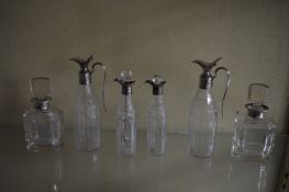 A pair of cut glass scent bottles with silver collars and two pairs of cut glass and silver