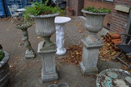 A good pair of reconstituted stone urn shaped garden planters supported on square shaped pedestal