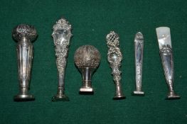 A collection of six white metal mounted desk seals.