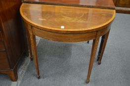 An inlaid mahogany demi-lune fold-over card table (faults).