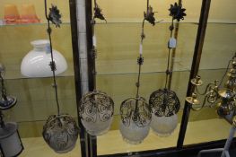 A pair of ornate gilt metal wrought iron hanging lanterns with two similar lamps.