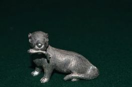 A small cast metal model of an otter with a fish in its mouth.