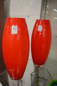A pair of large red cased glass vases.
