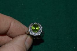 A silver ring set with a natural olive green 3ct peridot, with certificate.