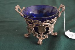 A silver sugar basket with blue glass liner.