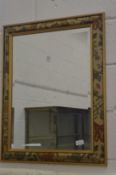 Modern wall mirror with floral decorated frame.