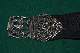A belt with white metal buckle or clasp.