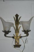 A wrought iron twin branch wall light with frosted glass shades.