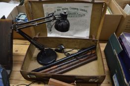 A suitcase containing an angle poise lamp, four Victorian rulers and a share certificate.