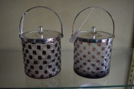 A pair of cut glass biscuit barrels with plated mounts.