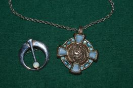 A Celtic medallion and chain and a brooch set with an opal.