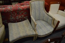A French style armchair with cream painted frame and matching foot stool.