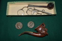 A carved wood pipe and other items.