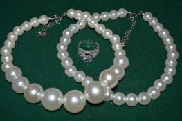 A double pearl necklace and decorative ring set.