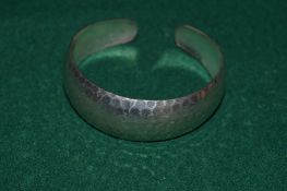 A hammered silver bangle.