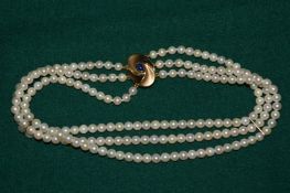 A pearl three row choker with 18ct gold and sapphire clasp.