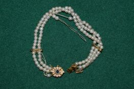 An 18ct gold mounted pearl necklace (faults).