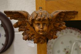 A small carved wood bust of a cherub.