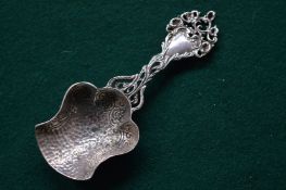A silver caddy spoon.