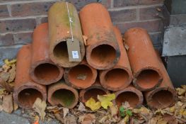 Eleven terracotta drain pipe sections (suitable for wine bottle holders).