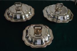 A pair of entree dishes and covers with a matching smaller entree dish and cover.