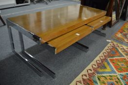 A stylish set of three chrome framed rosewood coffee tables.