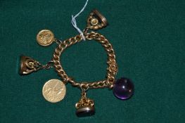 An 18ct gold curb link bracelet mounted with fob seals and charms and a 20 Kroner yellow metal