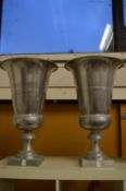 A large pair of aluminium urn shaped vases.