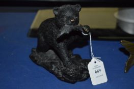 A Patinated brass model of a bear with a fish in its mouth.