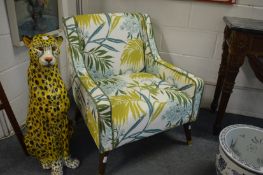 A pair of Next Nina Campbell design armchairs, upholstered with a green large leaf design fabric.