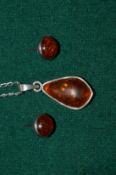 An amber pendant and chain with pair of similar earrings.