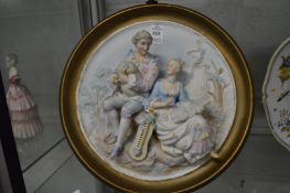 A pair of Continental bisque porcelain painted circular relief moulded panels depicting courting